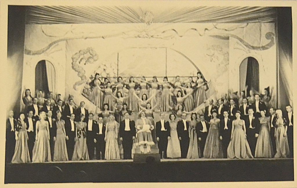 fotografie-teatru-de-revista-interbelic-ansamblu-perechi-plus-grup-de-femei-femeia-din-mijloc-are-bratele-mana-n-mana